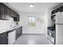 Updated kitchen with stainless steel appliances, white subway tile, and dark cabinetry at 7600 Kearney Dr, Commerce City, CO 80022