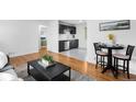 Open-concept living space with wood floors, a kitchen view, and stylish decor at 7600 Kearney Dr, Commerce City, CO 80022