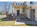 Inviting covered front porch with stately columns and a beautifully landscaped entrance at 10806 Crooke Dr, Parker, CO 80134