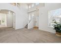 Bright living room featuring high ceilings, large windows, and a staircase at 10806 Crooke Dr, Parker, CO 80134