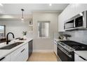 Modern kitchen features stainless steel appliances, sleek white cabinetry, and light hardwood floors at 1473 N Locust St, Denver, CO 80220