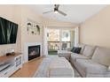 Comfortable living room featuring a fireplace, built-in shelves, a ceiling fan, and access to a private balcony at 8615 W Berry Ave # 203, Littleton, CO 80123