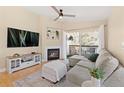 Comfortable living room featuring a fireplace, built-in shelves, a ceiling fan, and access to a private balcony at 8615 W Berry Ave # 203, Littleton, CO 80123