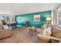 Cozy living room and dining area with a vibrant accent wall and stylish furnishings at 9787 W Ohio Ave, Lakewood, CO 80226