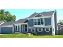 Charming two-story home featuring blue siding, stone accents, well-kept front yard, and mature trees at 21518 E Powers Ln, Centennial, CO 80015