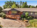 Beautiful brick house featuring a spacious wooden deck and well-maintained landscaping at 5460 S Olive St, Greenwood Village, CO 80111