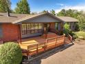 Lovely brick home boasts a sizable wooden deck for outdoor relaxation at 5460 S Olive St, Greenwood Village, CO 80111