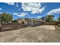 Charming home with gravel landscaping surrounding the property and a partially fenced yard at 1533 E Harlan, Lakewood, CO 80214