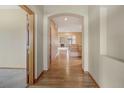 Inviting hallway with hardwood floors and arched doorways leading to the living area at 16231 Rayburn St, Hudson, CO 80642