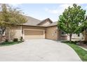 Beige home featuring an attached garage and spacious driveway at 6193 Terry Ct, Arvada, CO 80403
