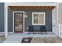 Inviting covered front porch features stylish seating and a modern front door at 18644 E 54Th Pl, Denver, CO 80249