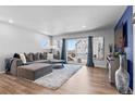 Bright living room features wood floors, and opens to balcony with sliding glass doors at 18644 E 54Th Pl, Denver, CO 80249