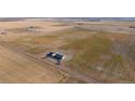 Expansive aerial view of property featuring home, surrounding farmland, and access road at 6 Timberlake Ct, Byers, CO 80103