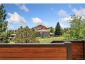 A scenic view of the home and the surrounding landscape with trees, blue sky, and mountains at 6457 Willow Broom Trl, Littleton, CO 80125