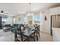Dining room with a table set for six, light fixture, with an open floor plan to the living room at 171 S Waterloo St, Aurora, CO 80018
