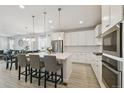 Bright, open kitchen with white cabinets, an island with seating, and stainless steel appliances at 171 S Waterloo St, Aurora, CO 80018
