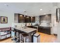 Updated kitchen boasts granite counters, dark cabinetry, and breakfast bar with seating at 2901 N Glencoe St, Denver, CO 80207