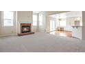 Bright and airy living room featuring a brick fireplace, windows, and seamless transition to a dining/kitchen area at 20271 E Lake Ave, Centennial, CO 80016