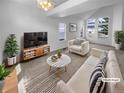 Bright, virtually staged living room featuring high ceilings, many windows, and modern decor at 10707 Milliken St, Parker, CO 80134