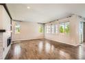 Spacious living room with hardwood floors, ample natural light, and a cozy fireplace at 15437 W 95Th Ave, Arvada, CO 80007