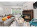 Bright living room with fireplace, large windows, stylish furniture, and wood-look flooring, perfect for relaxing at 3050 W 107Th Pl # E, Westminster, CO 80031