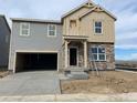 Two-story home featuring stone accents, an attached two-car garage, and a concrete driveway at 15295 Fillmore St, Thornton, CO 80602