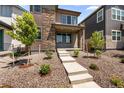 Beautiful front yard of a two-story home with a stone facade and concrete steps at 21044 E 63Rd Dr, Aurora, CO 80019