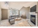 Bright living room featuring hardwood floors, fireplace, large windows and neutral décor at 7373 E Iowa Ave # 1112, Denver, CO 80231