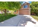 Inviting two-story home featuring a spacious driveway and lush green lawn at 4393 E Andover Ave, Castle Rock, CO 80104