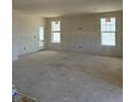 Bright living room under construction with drywall, large windows, and an exterior door at 30 Waterford St, Erie, CO 80516