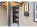 Close-up of the front door with modern design elements and contrasting black accents at 3210 Magnolia St, Denver, CO 80207
