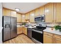Well-lit kitchen featuring stainless steel appliances, wood cabinets and modern countertops at 660 S Alton Way # 3B, Denver, CO 80247