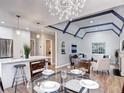 Open-concept dining area featuring modern chandelier and view into the living room at 1378 Forest St, Denver, CO 80220