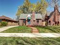 Charming brick home with a well-manicured lawn and inviting walkway to the front door at 1378 Forest St, Denver, CO 80220