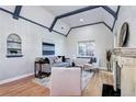 Bright living room boasts vaulted ceilings with wood beams, hardwood floors, and a cozy fireplace at 1378 Forest St, Denver, CO 80220