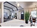 Bright living room with a fireplace, beamed ceiling and hardwood floors, seamlessly connecting to dining area at 1378 Forest St, Denver, CO 80220