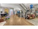 Spacious entryway with hardwood floors, a staircase, and a view of the living and dining areas at 13053 Umatilla Ct, Denver, CO 80234