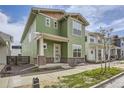Charming two-story home with green siding, well-manicured lawn, and sidewalk at 910 Promenade Dr, Superior, CO 80027