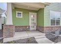 Welcoming covered front porch with brick pillars and a modern front door at 910 Promenade Dr, Superior, CO 80027