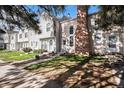 Charming two-story townhome exhibits tidy landscaping, neutral colors, and a brick chimney at 3231 S Estes St, Lakewood, CO 80227