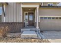 Inviting front entrance with decorative door, covered porch, and attractive landscaping at 12291 Coral Burst Ct, Parker, CO 80134