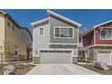 New construction exterior featuring a gray horizontal siding and a two-car garage with stone accents at 4327 E 98Th Pl, Thornton, CO 80229