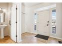 Bright foyer featuring tile flooring, a pedestal sink, a closet, and plenty of natural light at 4844 Mt Evans St, Brighton, CO 80601