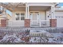Inviting front porch with brick accents and white railings offers a warm welcome to the charming home at 4844 Mt Evans St, Brighton, CO 80601
