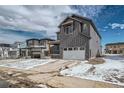 Charming two-story home featuring gray siding, a covered porch, and attached two car garage at 13729 Daffodil Pt, Parker, CO 80134