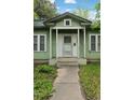 Close up of a one-story home's front porch entrance with light green paint and concrete steps at 1900 S University Blvd, Denver, CO 80210
