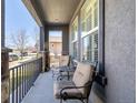 Inviting outdoor seating area on a cozy covered porch with nice chairs and a small table to enjoy your morning coffee at 16658 E 106Th Dr, Commerce City, CO 80022