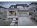 Two-story home featuring a two-car garage, a welcoming front porch, and a well-maintained front yard at 26881 E Roxbury Pl, Aurora, CO 80016