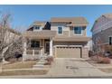Two-story home with a two-car garage, a welcoming front porch, and a landscaped front yard at 26881 E Roxbury Pl, Aurora, CO 80016