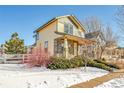 Delightful two-story home showcases lovely curb appeal with stone accents and inviting front porch in a wintery setting at 1172 S Coolidge Cir, Aurora, CO 80018